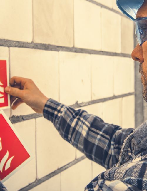 Un homme qui colle des signalisations au mur
